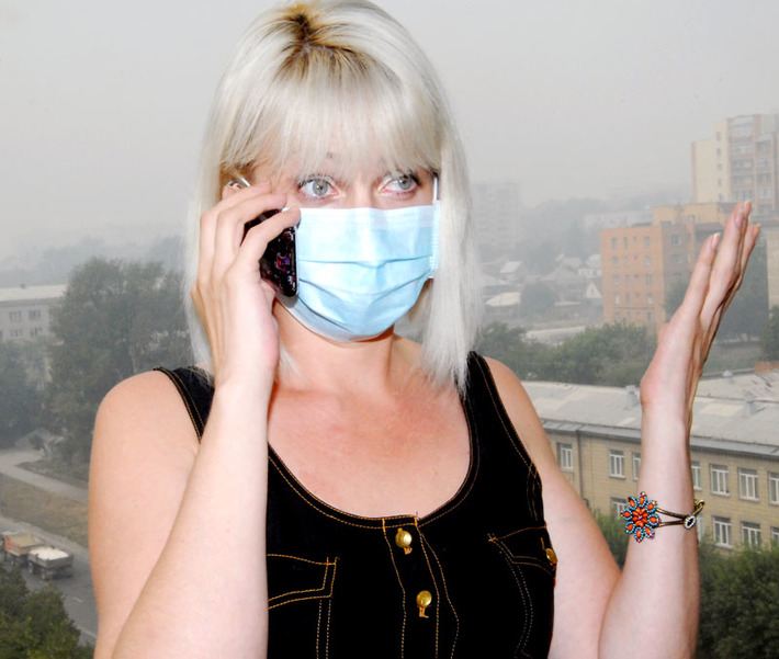 Над Новосибирском висит плотная завеса смога. И вроде гарью не пахнет, а дышать тяжело. В воздухе — взвесь из частиц пыли и дыма. Некоторые новосибирцы появляются на улице только в масках. Фото Михаила ПЕРМИНА