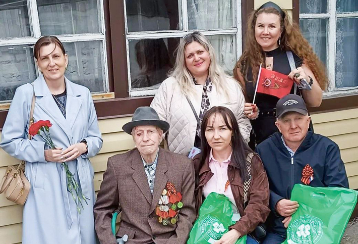 В центре снимка: Доля Сергей Иванович. От имени коллектива АО "Толмачевские Продукты" поздравили ветеранов с Днем Победы, подарили цветы и праздничные наборы (справа налево): нижний ряд – Генеральный директор Щукин Владимир Максимович, бренд-менеджер Алексеева Анна Юрьевна; верхний ряд – супервайзер Ершова Мария Павловна, управляющая сетью магазинов Молтусова Ирина Романовна, руководитель кадровой службы Петрова Наталья Викторовна. Фото: Светлана Дубинина